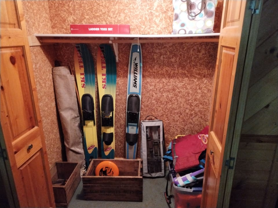 Closet of outdoor supplies lower level near pool table: life jackets, games, etc