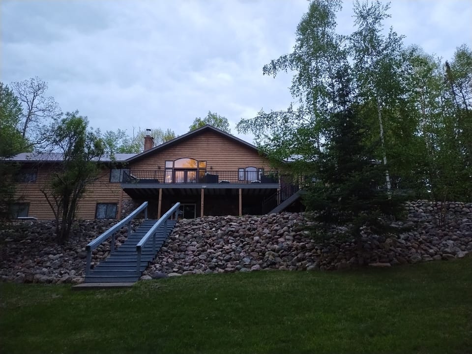 Back of lake home with steps leading down to lake front