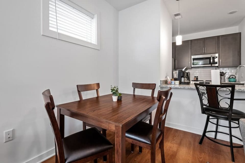 Cozy dining area with a table for four, plus additional bar‑stool seating at the kitchen island. Perfect for shared meals, morning coffee, or planning your day in Old Town Manchester.