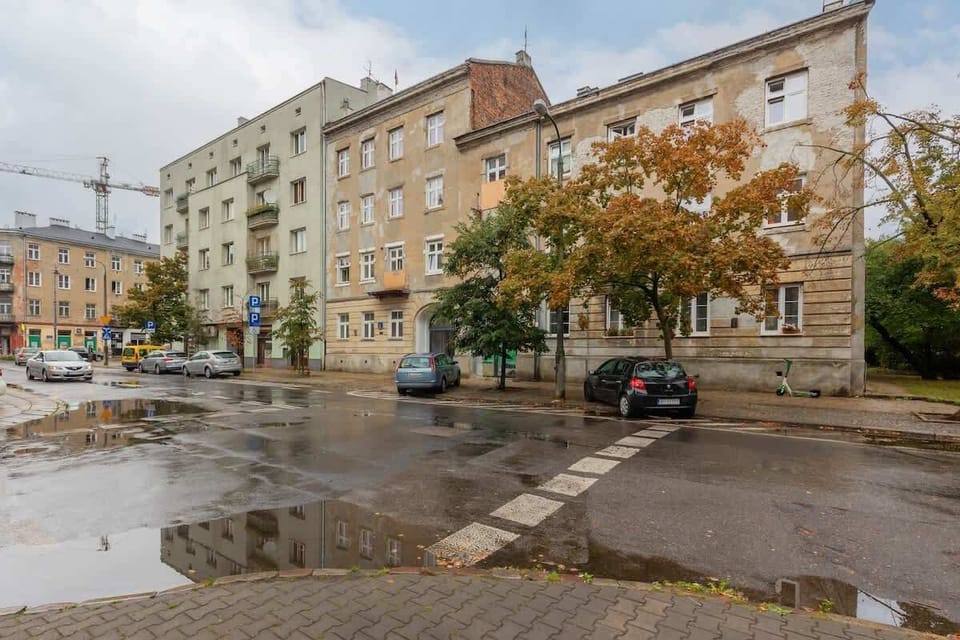 An outdoor view of the building’s façade and street, captured in overcast weather.


