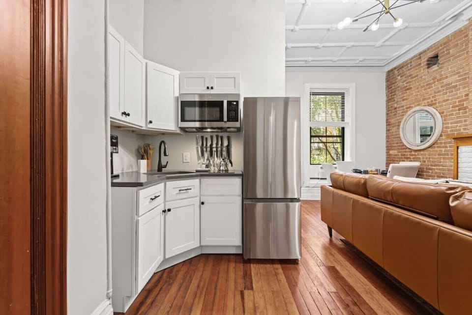 The kitchen features high-quality stainless steel appliances, such as a versatile 5-in-1 air fryer, an oven, and a microwave. These contemporary conveniences provide a variety of cooking options, ensuring a smooth cooking experience.
