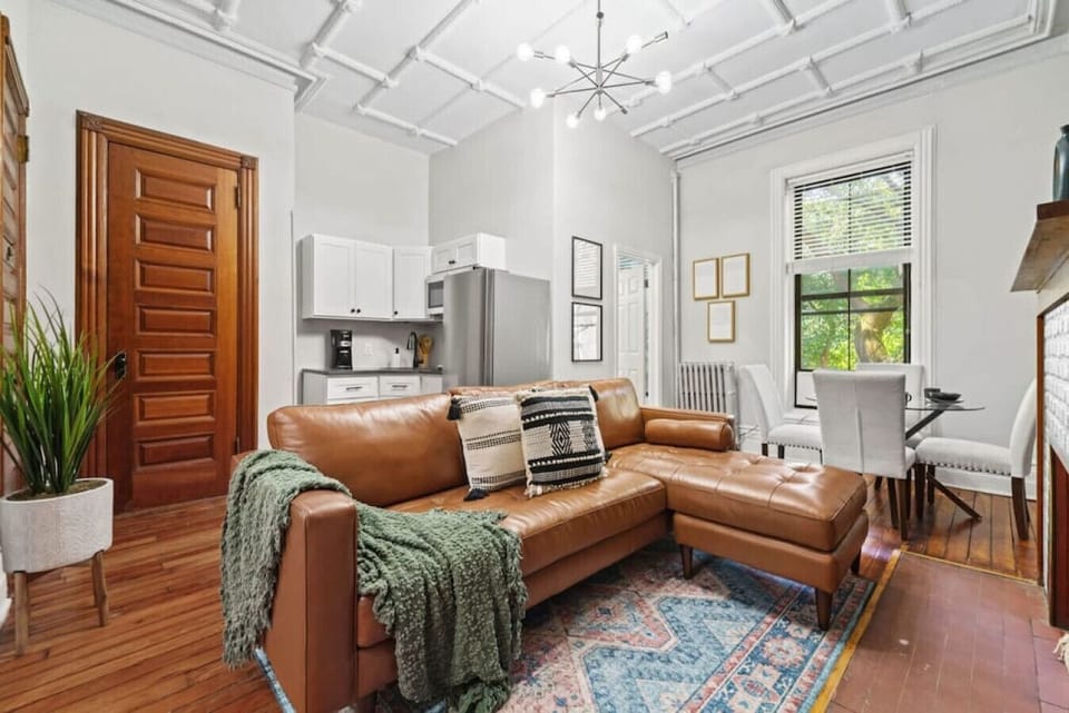 The living room features a brown leather couch that matches the door and floor, creating a cohesive look. This thoughtful design creates a comfortable and inviting space to relax.