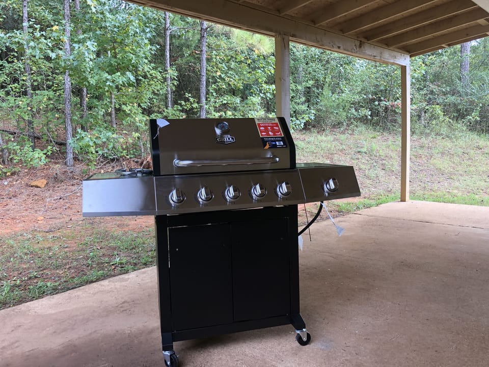 Five burner propane Grill on large covered patio & Forest on two sides