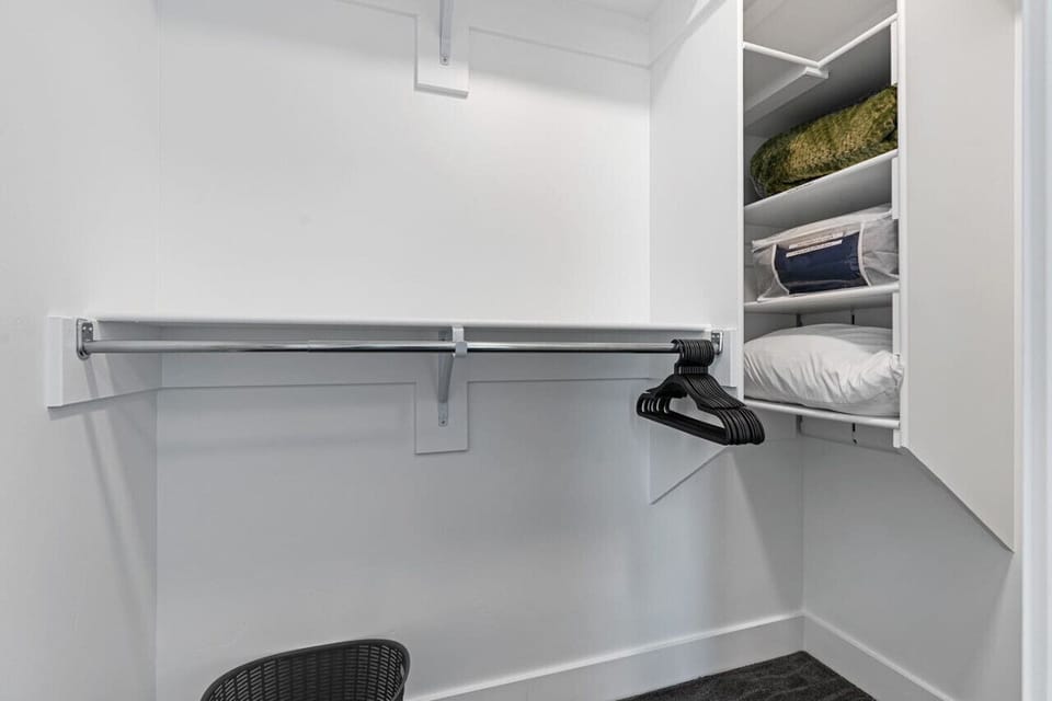 A large and comfortable walk in closet. Iron Ironing Board, Hangers, Luggage Racks.