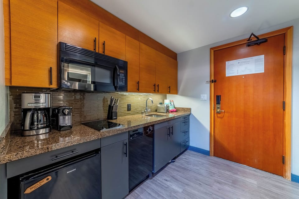 Kitchenette has glass stovetop, refrigerator, microwave, and dishwasher.