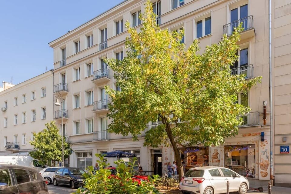 An exterior view of the building, surrounded by greenery and a calm neighborhood.
