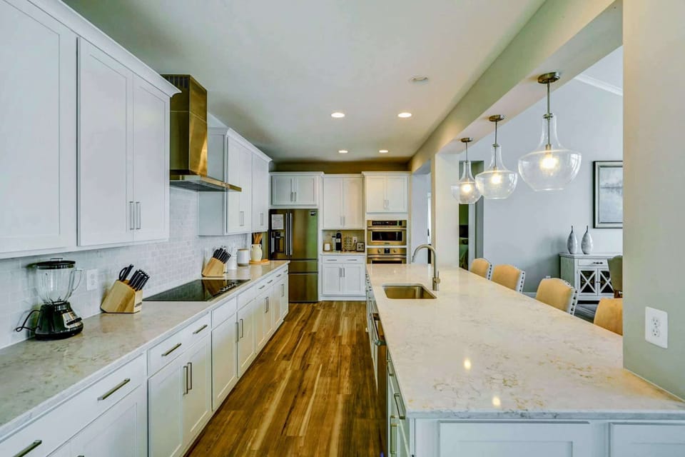 Large fully stocked kitchen with huge island, new stainless steel appliances, and large pantry.