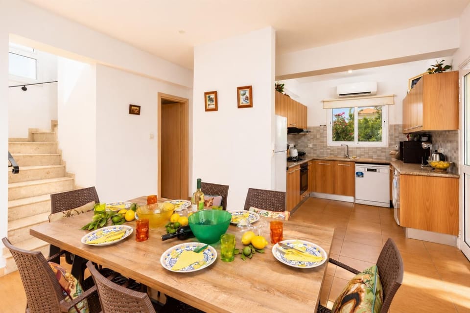 Open-plan living room with sofas, dining area, kitchen, A/C, WiFi internet, and satellite TV