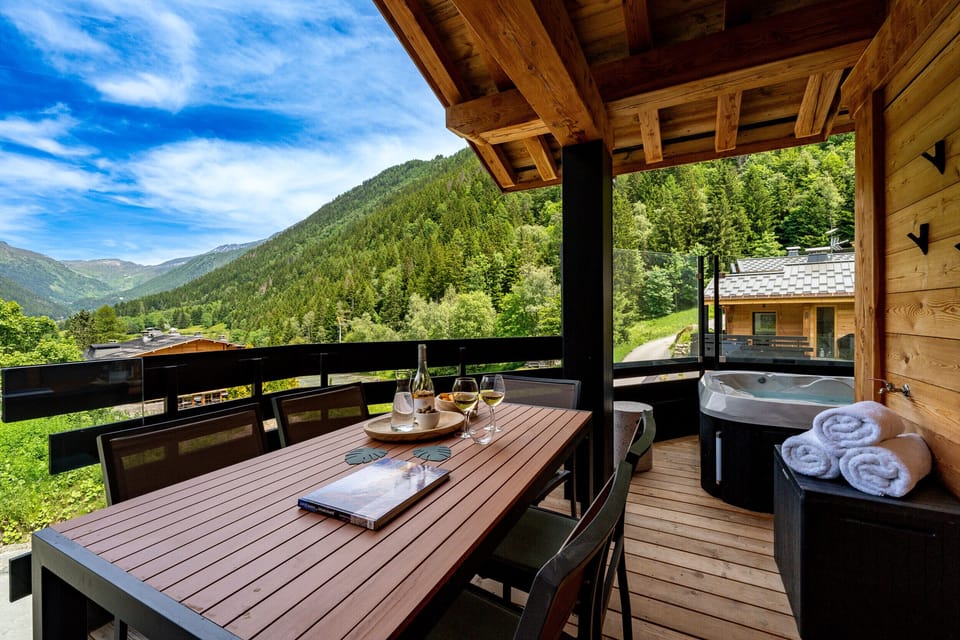 Large balcony off living area with hot tub and dining table