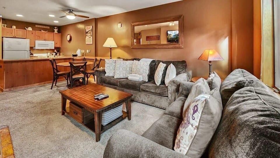 The living room offers a comfortable common area for relaxing with a gas fireplace, a three-person couch, a loveseat, and a 55” TV.