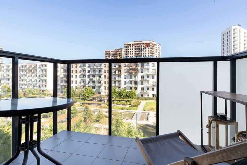 A view from the balcony, featuring outdoor seating and a scenic cityscape in the background.
