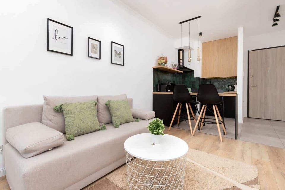 A small corner with a white TV stand, shelves, and green accents for a tidy, minimalist look.

