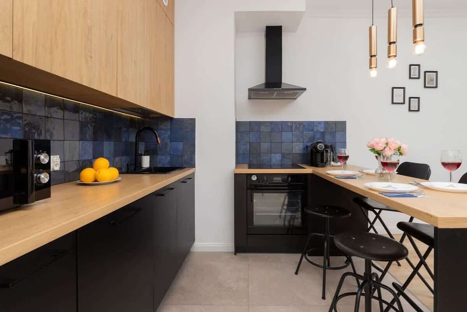 A closer kitchen view with a stovetop, cabinets, and yellow kitchen accessories on a wooden countertop.