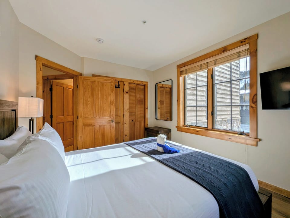 Sink into crisp white linens and wake to natural light streaming through your window in this cozy bedroom retreat.