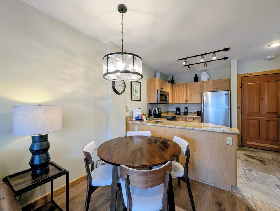 Your open-concept kitchen and dining area invites culinary adventures with granite counters, stainless appliances, and a warm wood table perfect for morning coffee or evening meals.