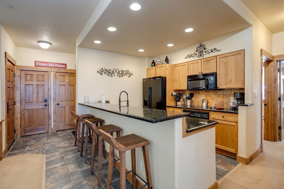 Your open kitchen invites culinary adventures with granite counters, breakfast bar seating, and modern appliances—perfect for mountain getaway meals.