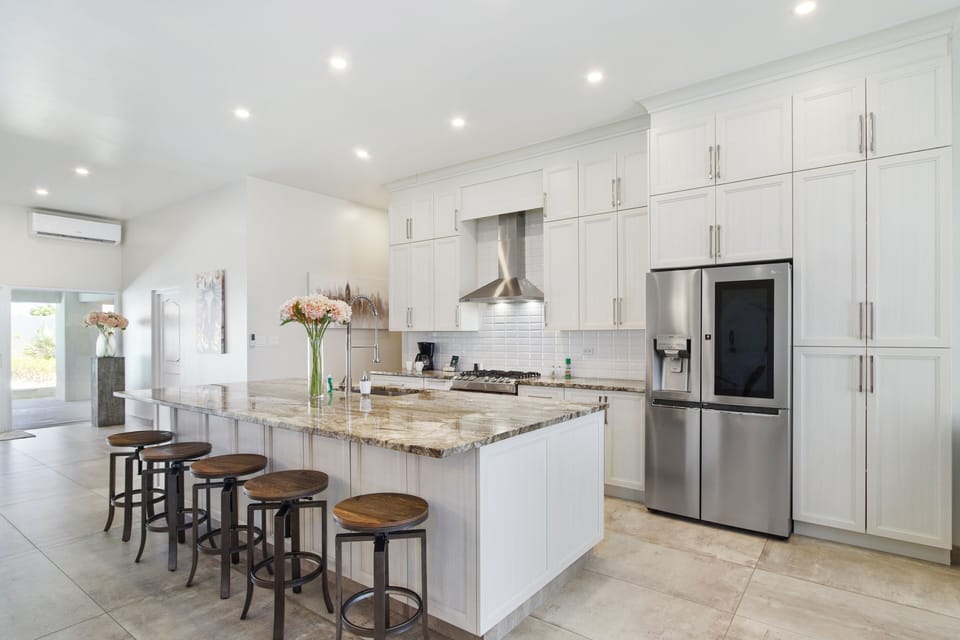 Imposing Kitchen of the Villa in Noord Aruba - Modern kitchen with sleek, stainless steel appliances - Integrated appliances for a seamless and stylish appearance - Smart use of space with versatile storage solutions