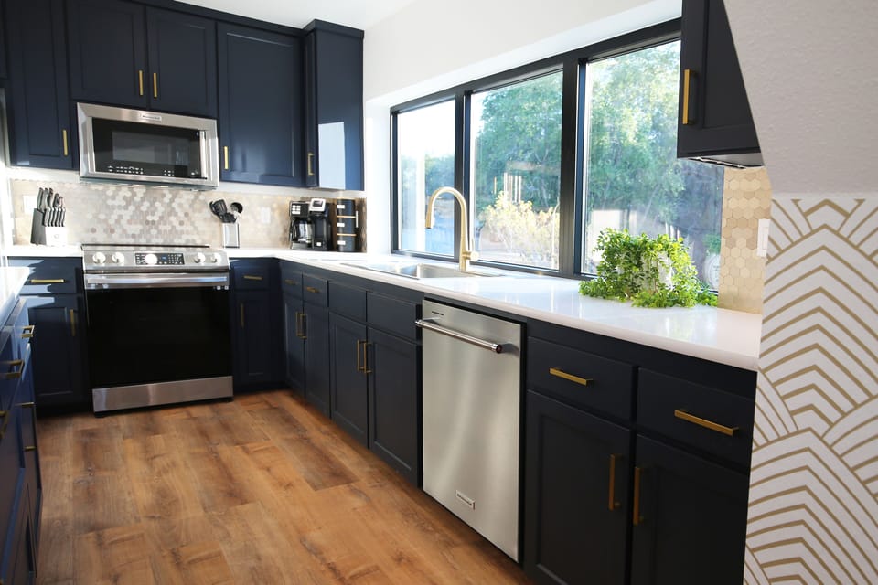Quartz countertops, a gold backsplash and stainless steel appliances. 