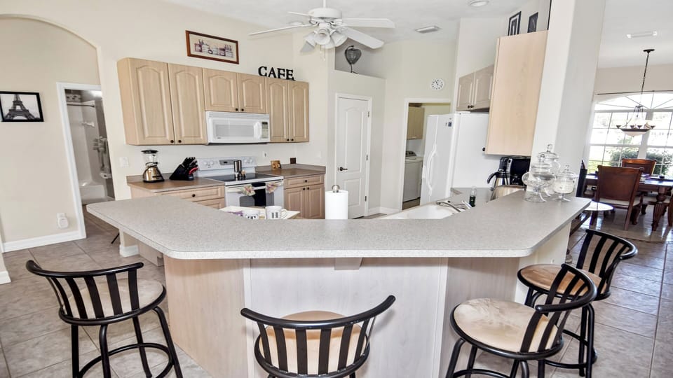 Full equipped kitchen with counter and bar chairs 