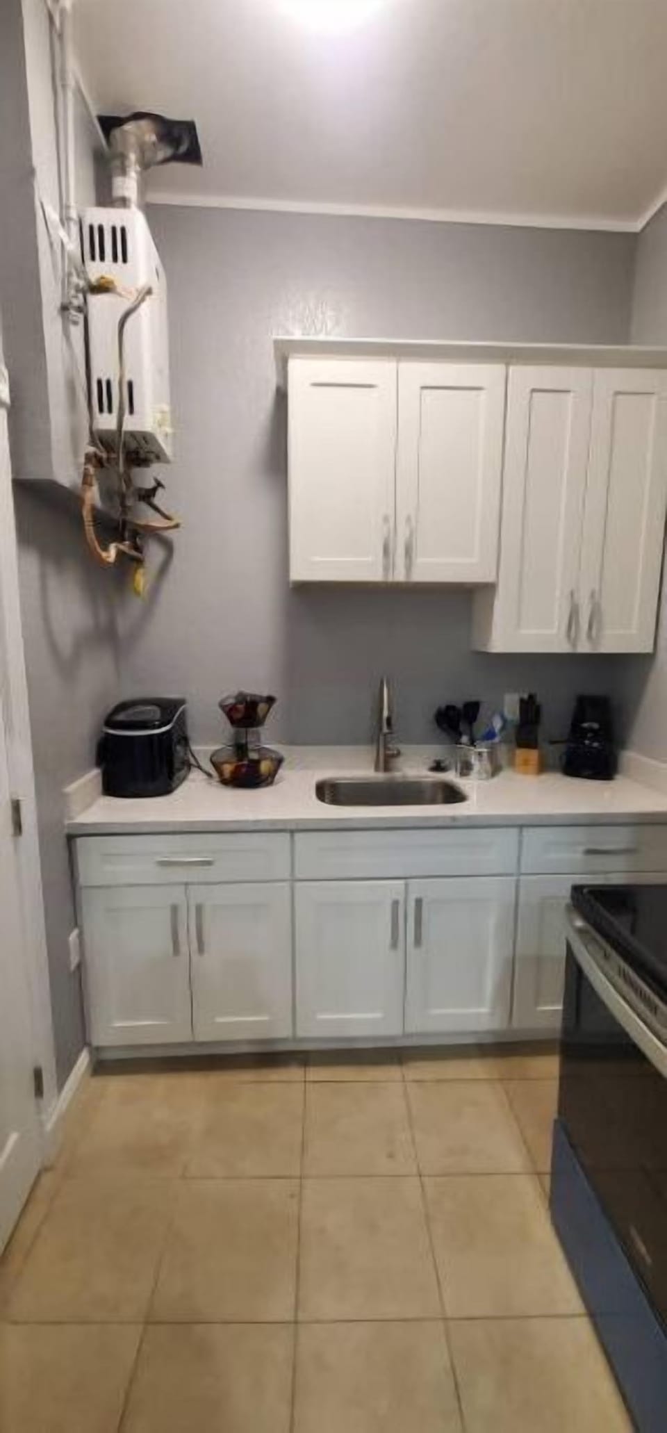 The kitchen has a tankless water heater on the wall in the upper left corner.