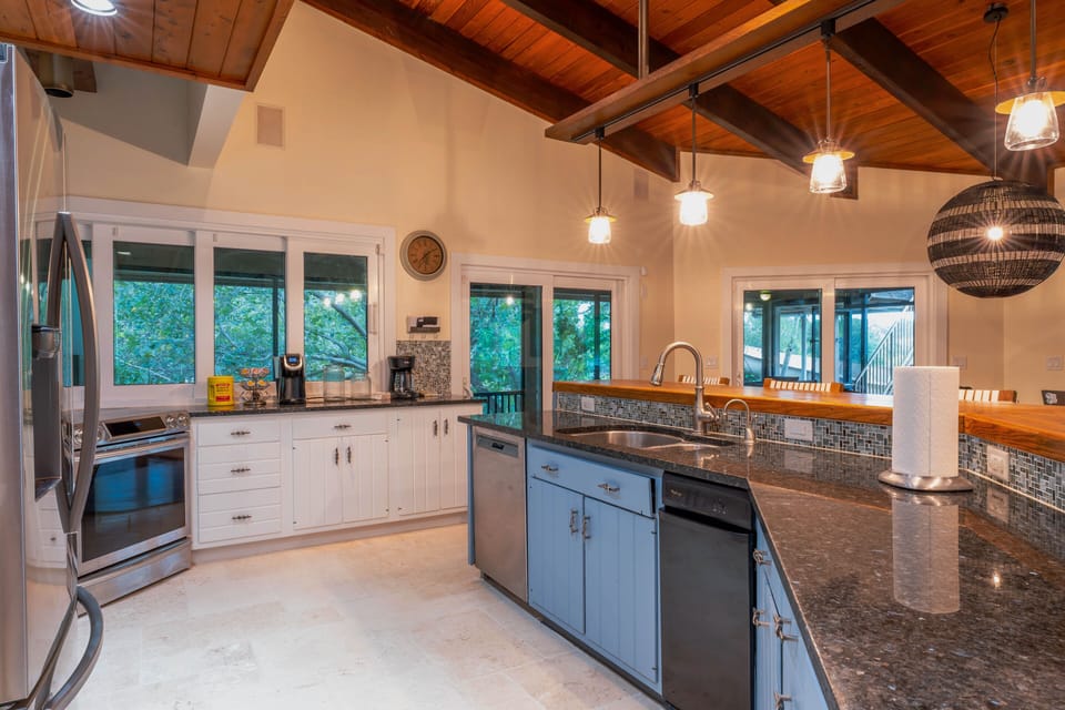 Take in the kitchen view, featuring a dishwasher, a fridge, and an island sink