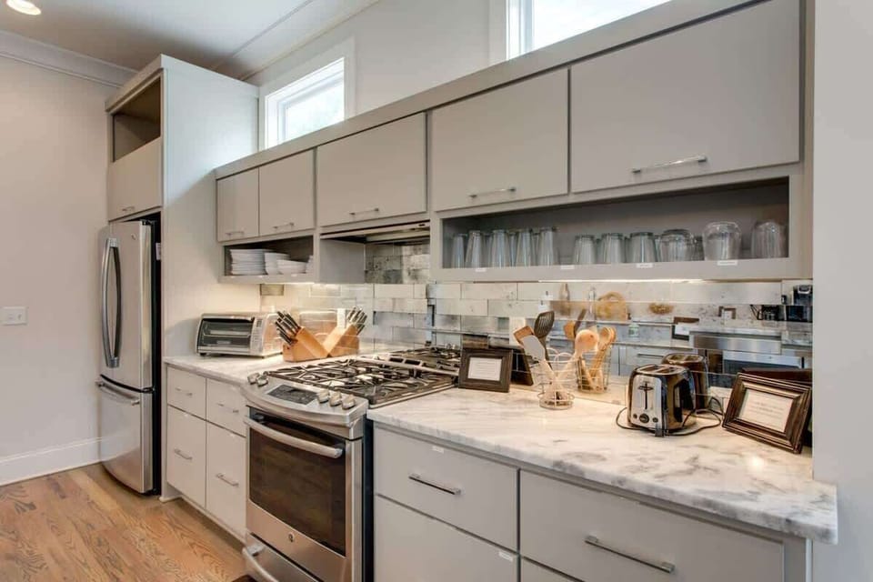 Every tool at your fingertips, framed by sleek cabinetry and sunlit marble elegance.