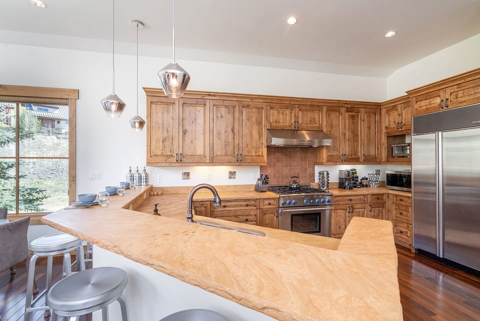 Chef's kitchen with stainless steel appliances, 6-burner gas stove, and generous counter space for cooking and entertaining.