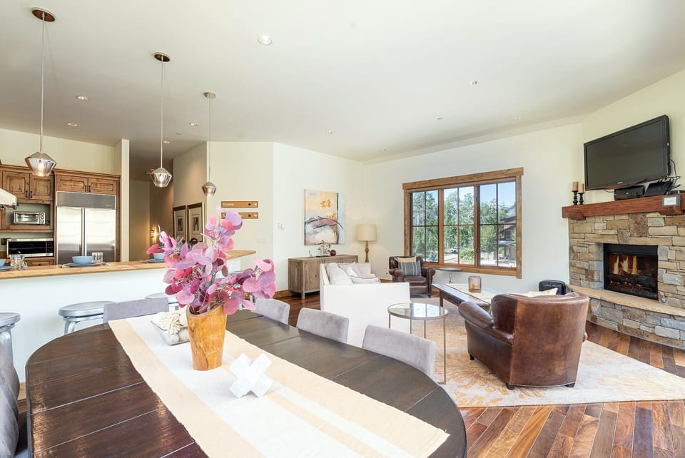 Bright open-concept living and kitchen space featuring stunning views, a gas fireplace, and a private deck.