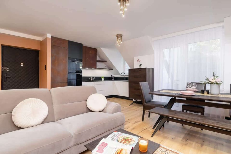 A spacious living and dining area with modern furnishings, white curtains, and an open layout.