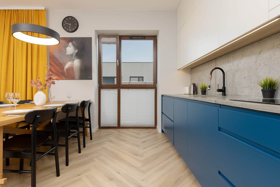 A stylish kitchen with white upper cabinets and vibrant blue lower cabinets, featuring a clean, modern layout with ample countertop space.