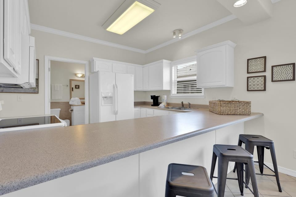 Kitchen - The spacious kitchen features a large, eat-in style bar with seating.
