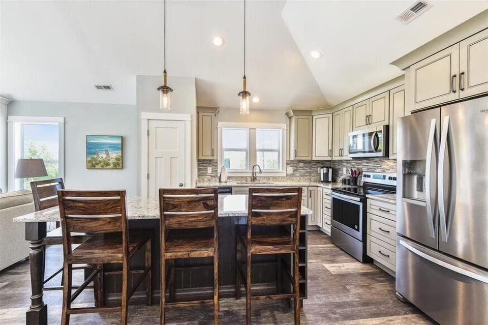A tasteful off-white kitchen with a dining table, perfect for both cooking and sharing meals.