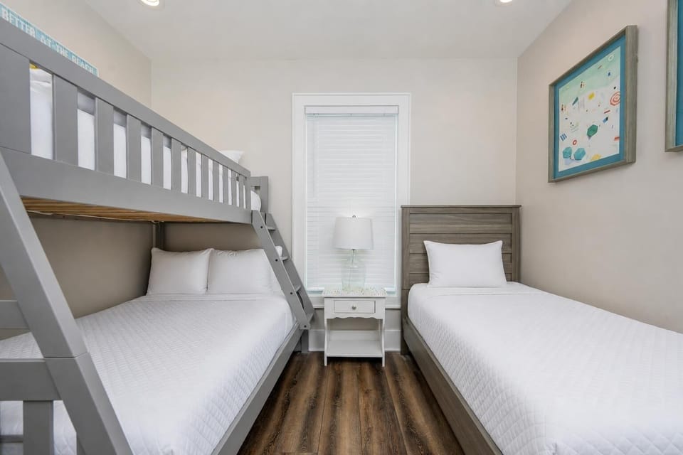 This cozy guest bedroom features a stylish bunk bed and a single bed, perfect for family stays, with cheerful decor