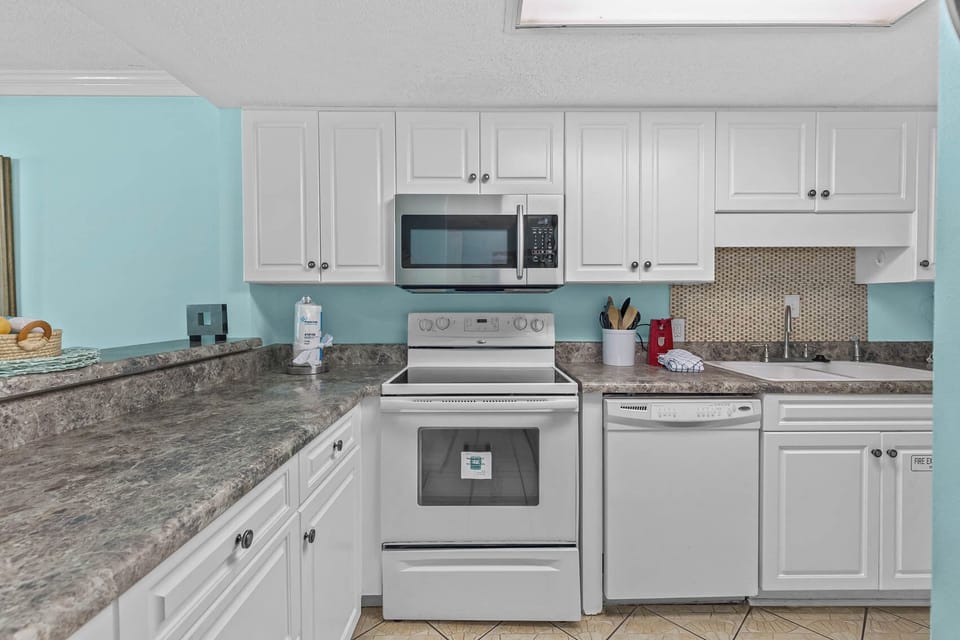 Kitchen featuring stainless appliances and a lovely turquoise accent wall for a cheerful cooking experience