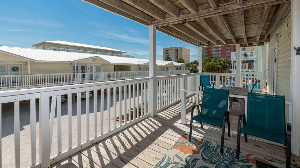This inviting balcony features teal chairs and a table, perfect for enjoying a relaxing view of the surrounding area