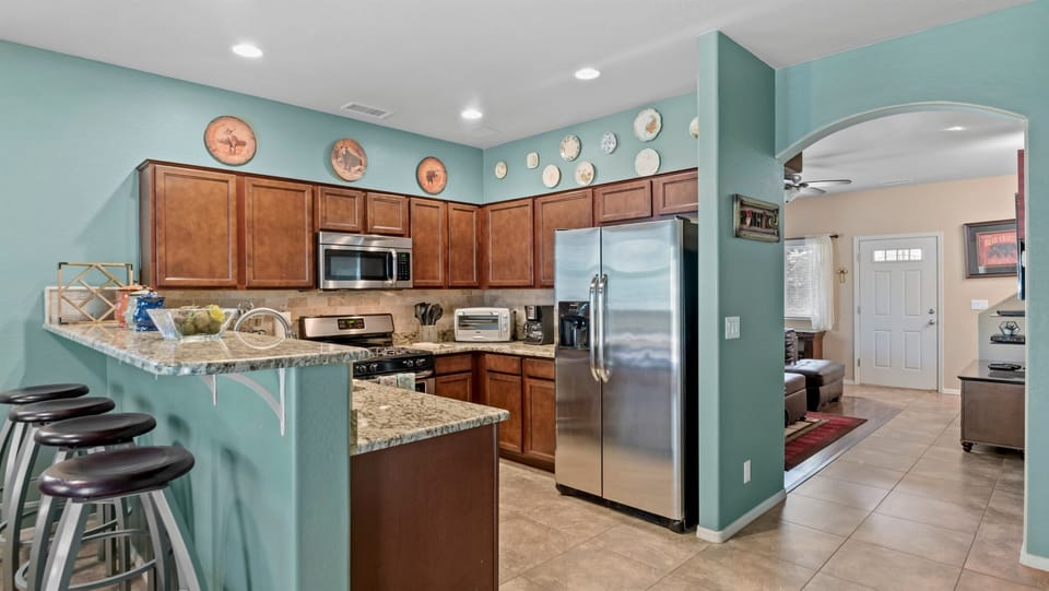 Gather at the breakfast bar, perfect for quick bites or morning coffee, with a view of the welcoming front door.
