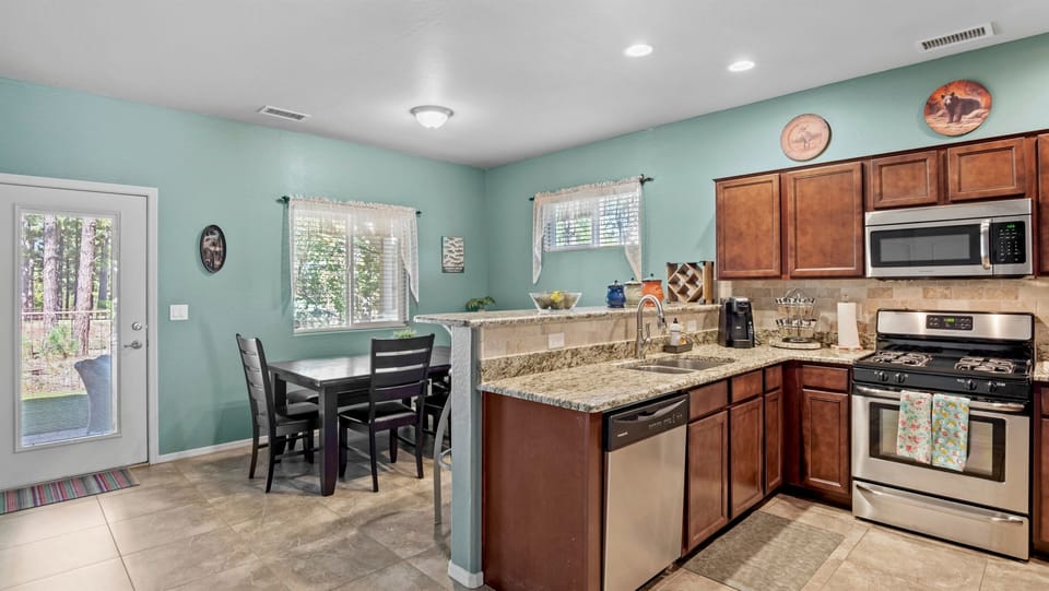 Functional kitchen with a breakfast bar for four, seamlessly connecting to the dining space for convenience.