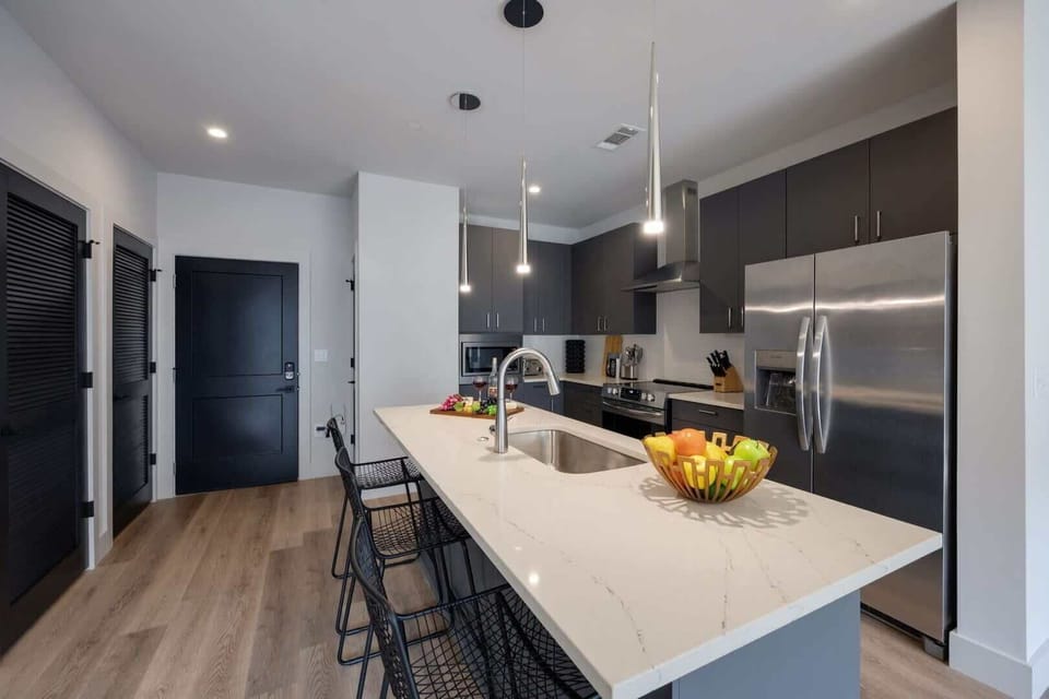 Fully equipped kitchen stocked with your basic cooking essentials. Includes stainless steel appliances, small kitchen island, coffee machine, and toaster.