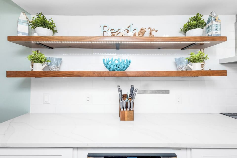Cook with ease in your beautifully appointed kitchen, where warm wood shelves and coastal touches create the perfect backdrop for your vacation meals.