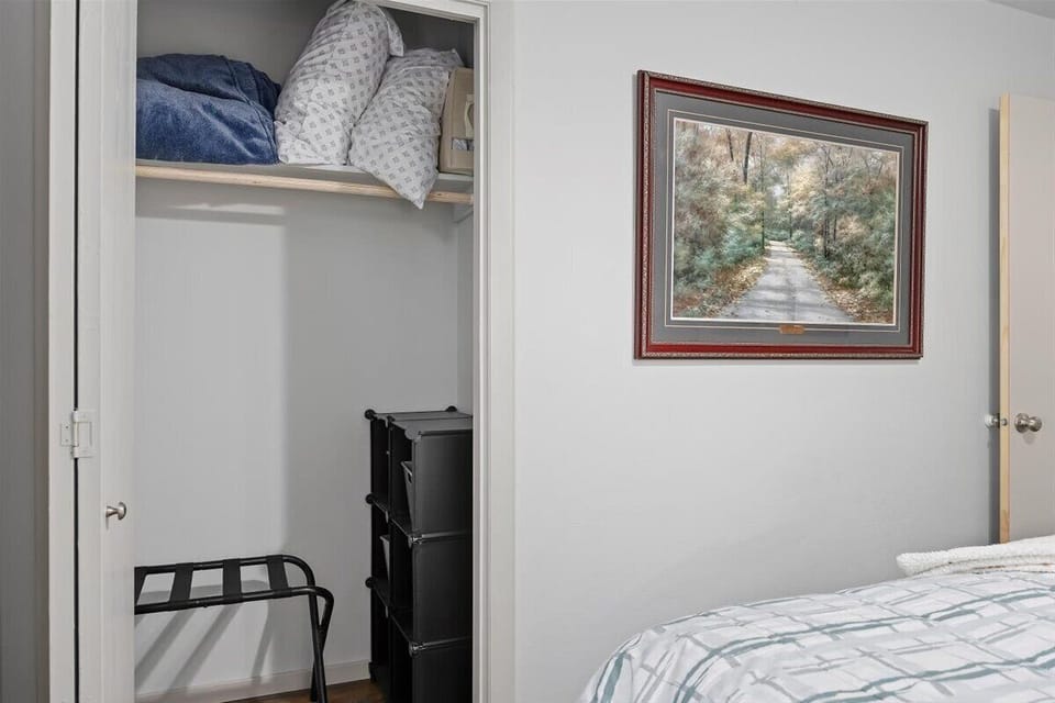 Queen closet with extra bedding, storage and luggage rack