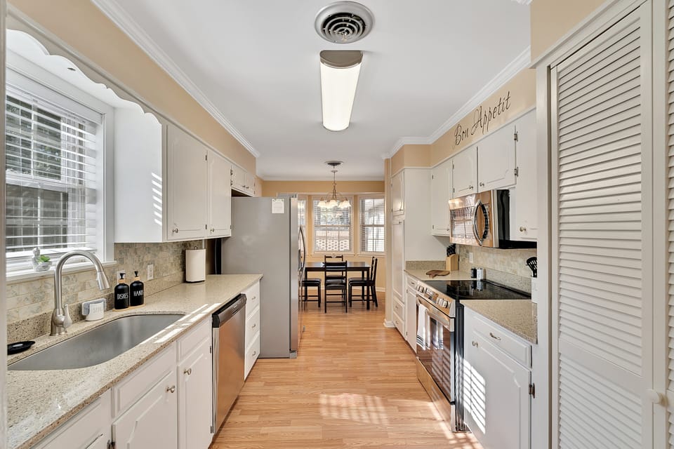 Fully equipped kitchen ft. kitchen hallway and the dining area at the far end