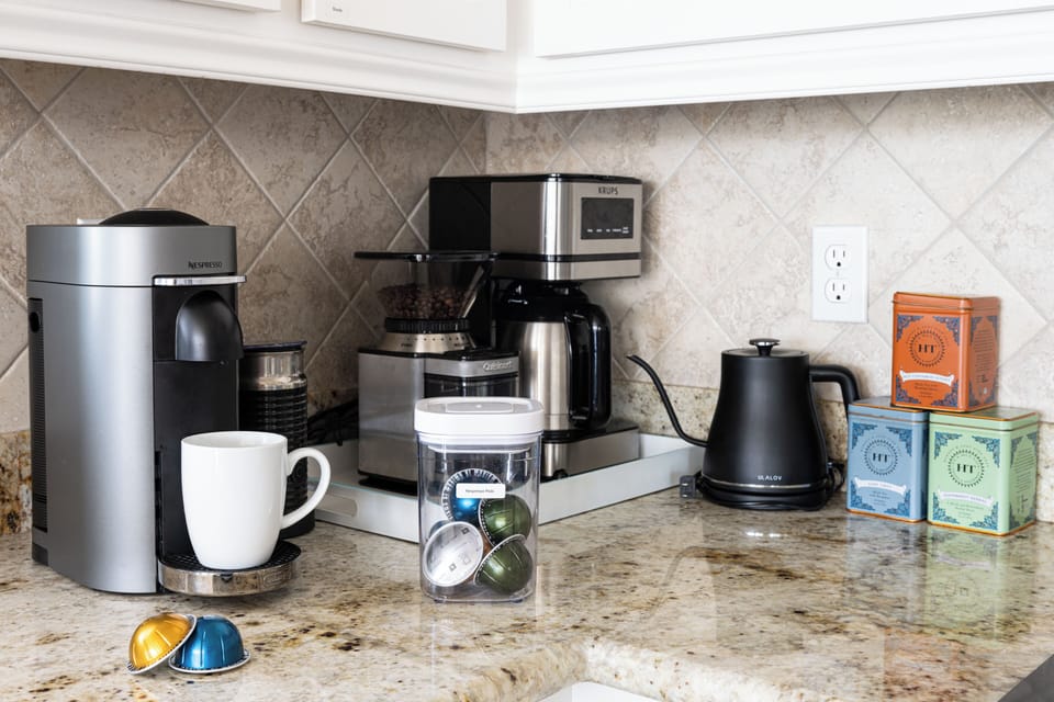 Fully stocked coffee and tea bar. We have a drip coffee maker, a Nespresso with frother, a burr grinder for beans, and a hot water kettle for tea and pour over coffee. We start you off with a supply of beans and 10 Nespresso pods.