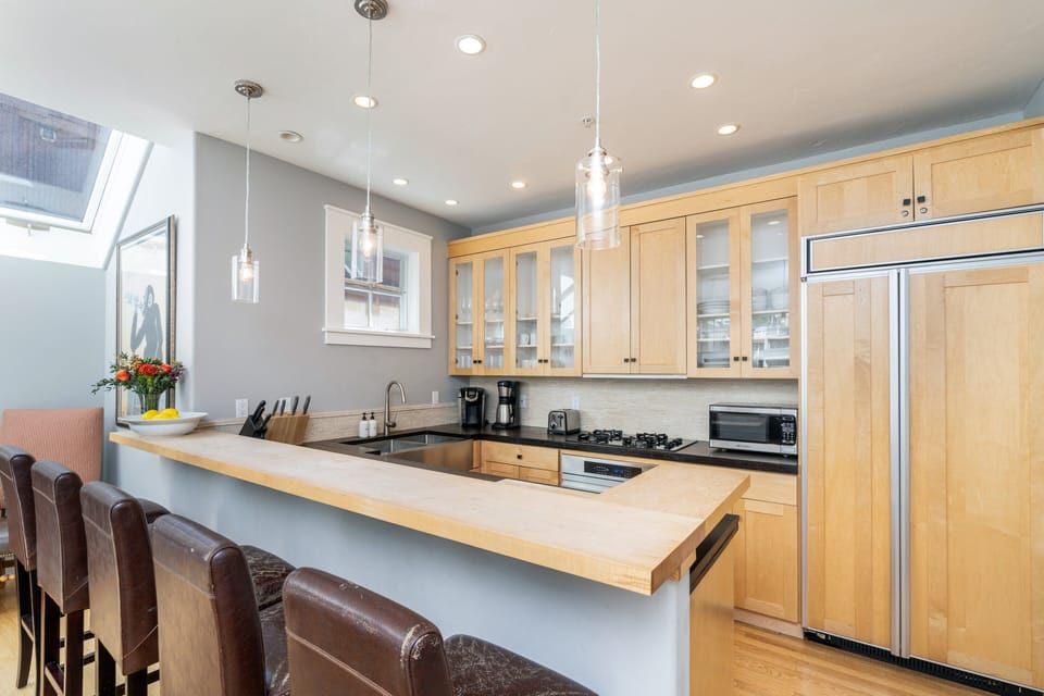 Chef's kitchen with stainless steel appliances and generous counter space for cooking and gathering.
