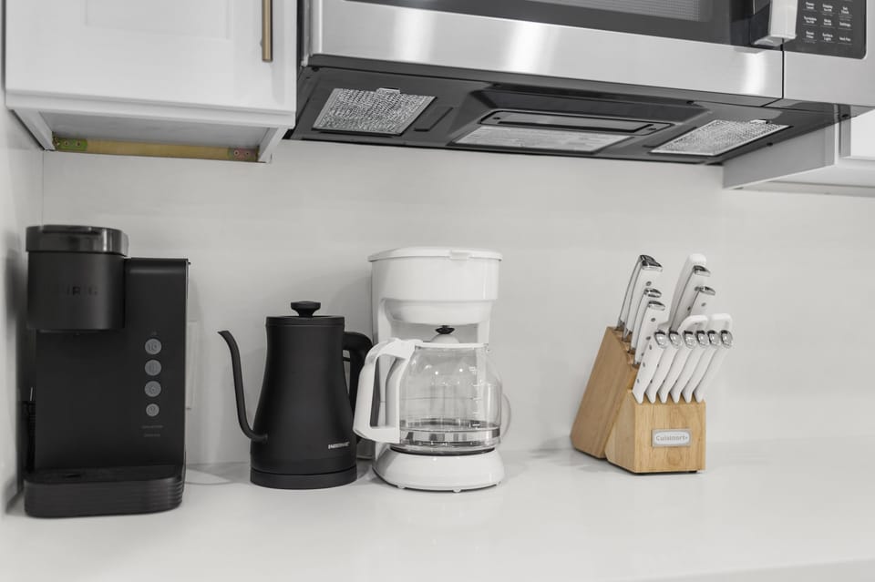 Kitchen with Keurig machine, hot water kettle, and drip coffee maker.