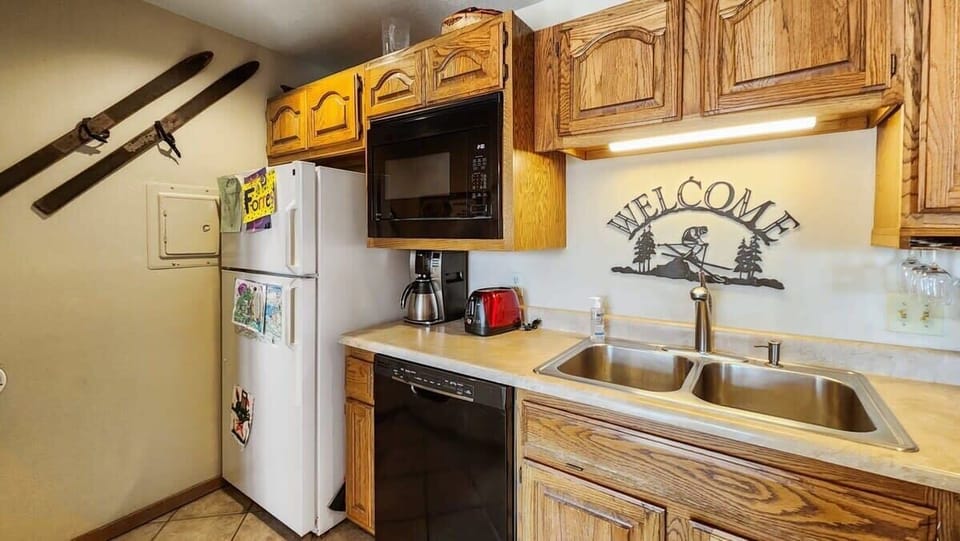 The fully equipped kitchen features a double-basin sink, spacious countertops, and a full range of appliances, from a blender to a toaster to a crockpot.