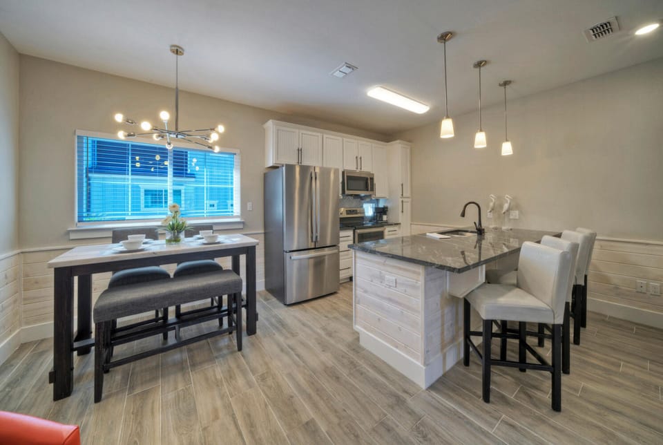 Modern chef's kitchen adjacent to dining space.