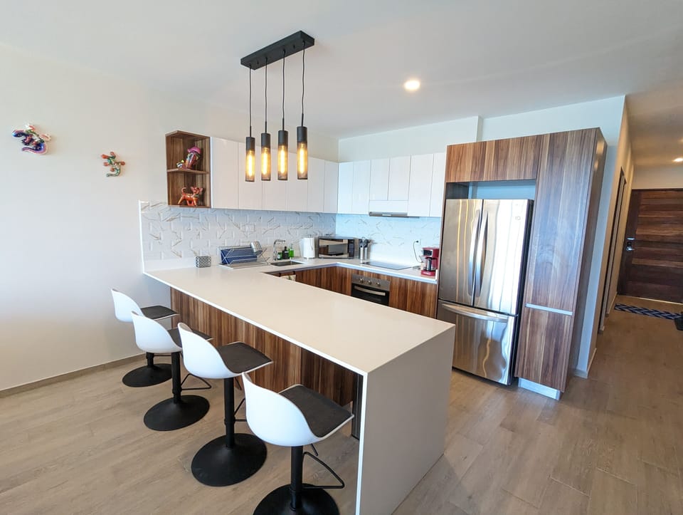 The kitchen bar area offers a comfortable sitting area with 4 bar tools.
