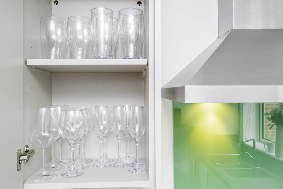 The kitchen is equipped with a diverse selection of glassware and cups.