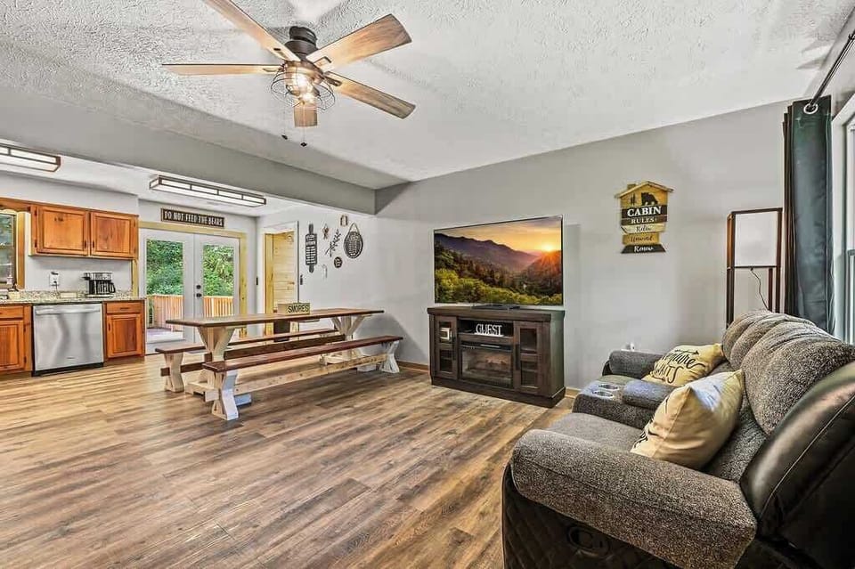 Gather around the farmhouse table for meals, then relax in the cozy living room with a mountain view on screen.
