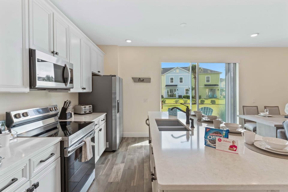 Polished kitchen of the cottage in Kissimmee Florida - With sleek appliances, ample counter space, and a chic dining set - Designed for both culinary creativity and elegant dining experiences